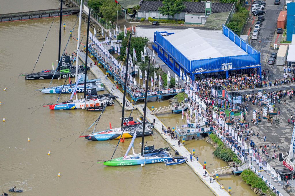 Vista aérea da Vila da Regata em Itajaí com público reunido para a The Ocean Race, evento que movimentou R$ 100 milhões na economia local.