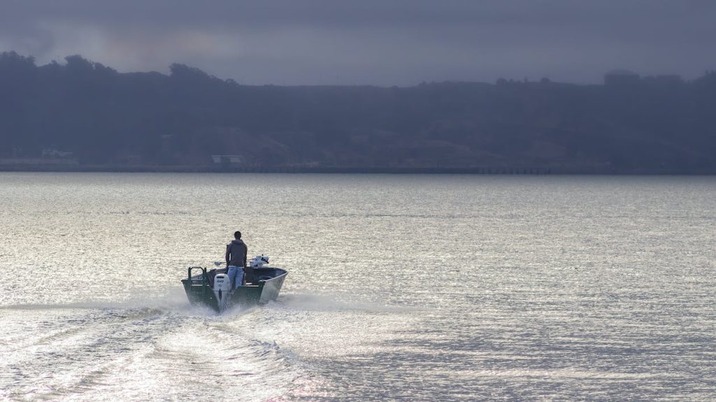 Homem navegando de barco em mar aberto próximo a Itajaí — habilitação náutica e segurança na navegação
