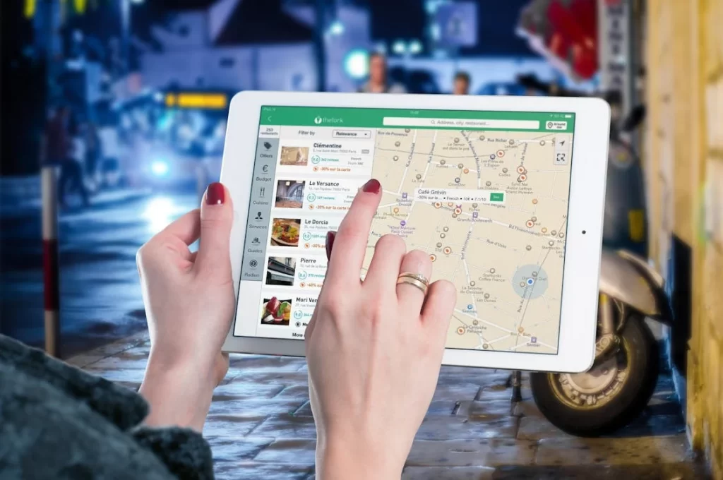 Mãos segurando tablet exibindo um mapa digital interativo