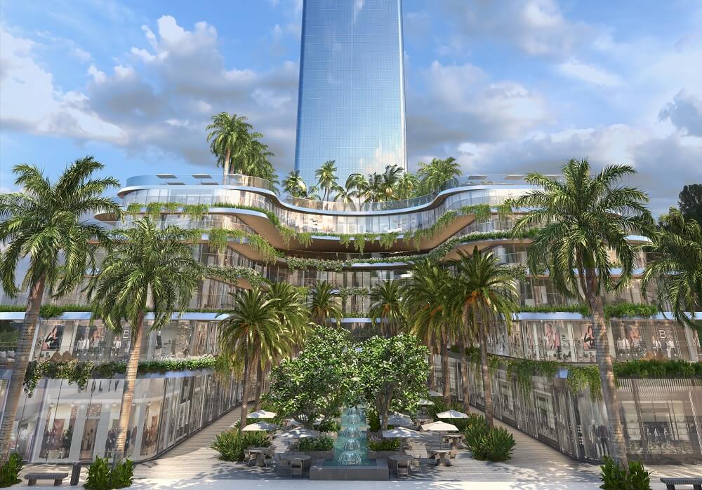 Visão interna do open mall da FG Tower em Balneário Camboriú, mostrando terraços em camadas com vegetação, palmeiras centrais e área de convivência com espelho d’água