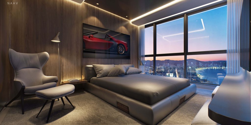 Suíte moderna ao entardecer com cama king-size de couro cinza, painel de madeira escura, poltrona de leitura com apoio, quadro de carro esportivo, iluminação indireta e janela panorâmica com vista noturna da cidade costeira.